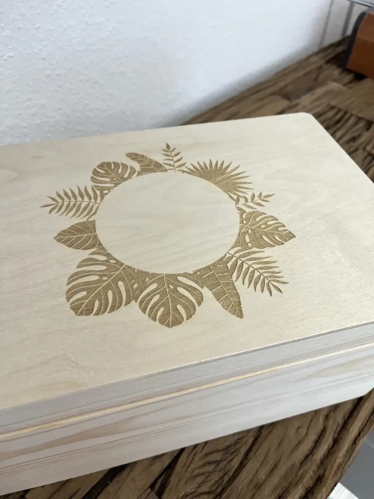Holzbox mit gravierten Blättern als botanischer Kranz auf dem Deckel